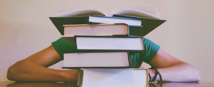 stack of books with student